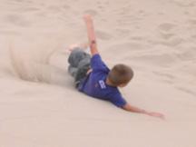 Kyle rolling down sand dune
